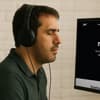 Person with visual impairment using a screen reader and headphones to navigate a website